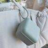 BIBS Pacifier Box in Baby Blue hanging from a stylish bag, showcasing its compact design and convenient portability.