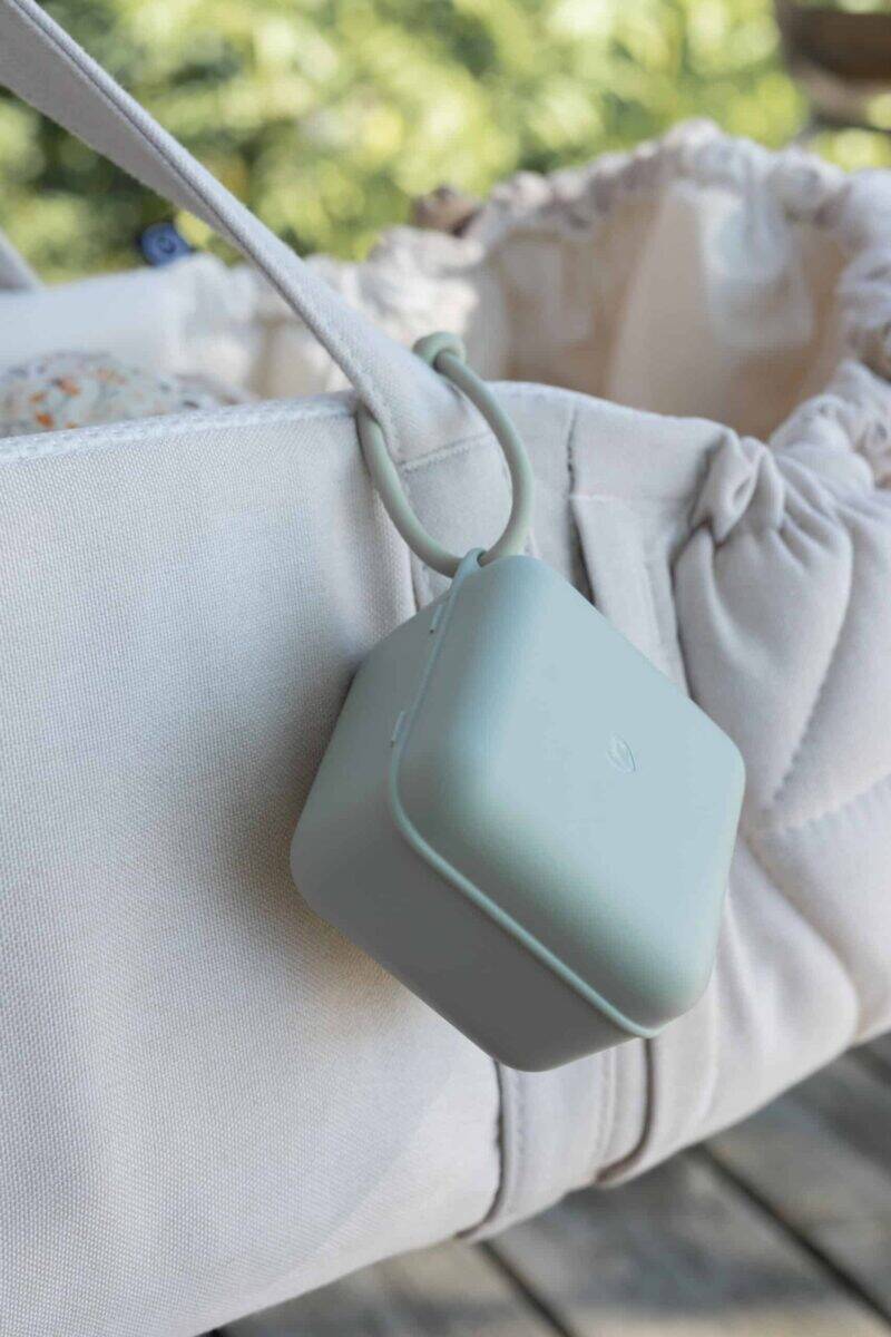 BIBS Pacifier Box in Baby Blue hanging from a stylish bag, showcasing its compact design and convenient portability.