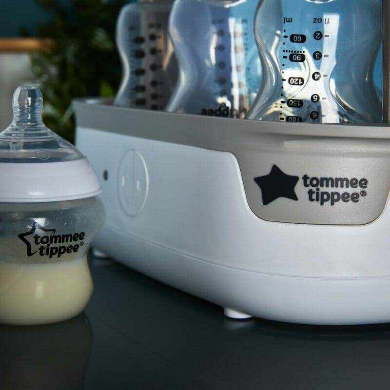 Tommee Tippee Super-Steam Advanced Electric Steriliser in white with a baby bottle and lid, showcasing its sleek design.