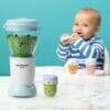 Nutribullet Baby blender in light blue with green peas, child sitting at table with colorful storage cups and spoon.