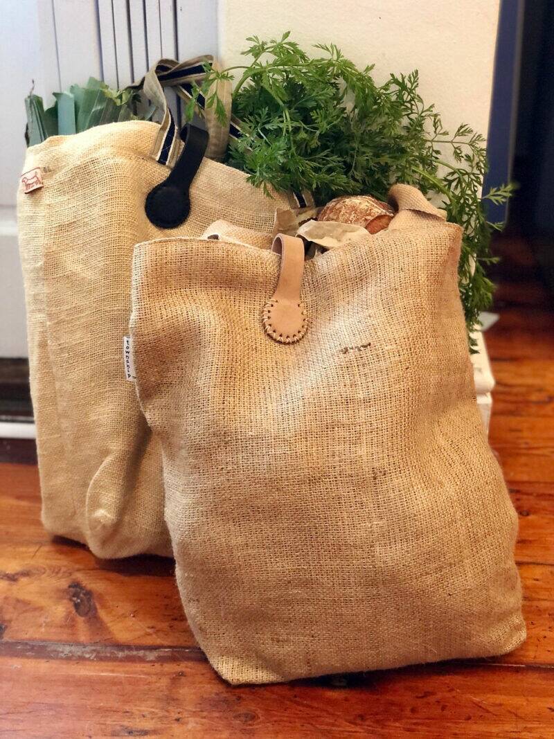 Natural jute bags from The Stella Clip in Beach Bébé and Bokke - Sage/Cream, filled with fresh produce and herbs.