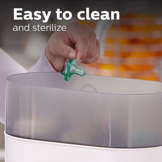 Philips Avent Newborn Soothie in green being placed into a sterilizer, highlighting its easy cleaning feature.