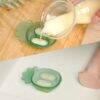 Haakaa Freeze-N-Feed Mini Combo in Pea Green, featuring a pineapple design, being filled with puree from a container.