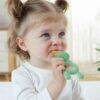 Haakaa Freeze-N-Feed Mini Combo in Pea Green, a baby feeding aid held by a child, showcasing its playful design.