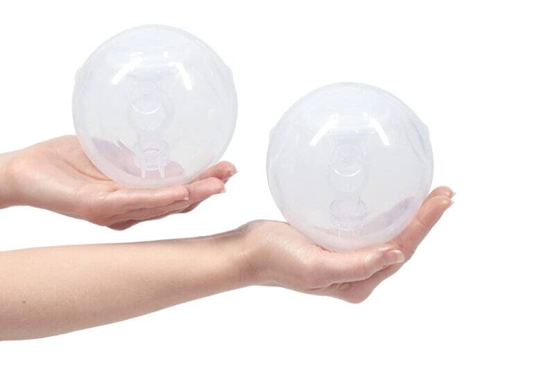 Spectra Handsfree Cup Set in clear, held in two hands, showcasing the 24mm and 28mm sizes for breast pumping.