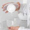 Spectra Handsfree Cup Set in white, showing a user pouring milk into the collection cup, highlighting its practical design.
