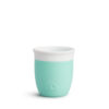 Munchkin C'Est Silicone Open Training Cup in mint green with a white rim, featuring a heart logo on the side.