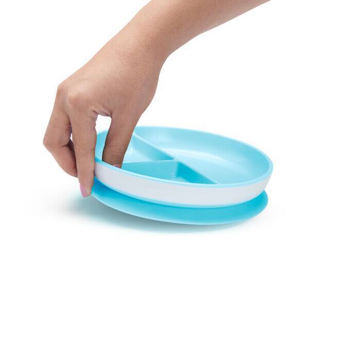 Munchkin Stay Put Suction Plate in blue, featuring a divided design, being lifted by a hand.