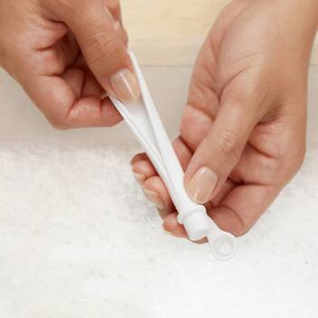 Munchkin Simple Clean Straw Cup in blue and pink, showing hands cleaning the straw in soapy water.