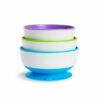Munchkin Stay Put Suction Bowls in purple, green, and blue stacked with a blue base, designed to prevent spills.