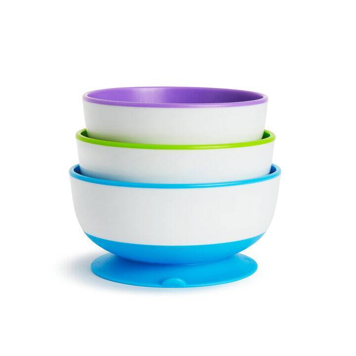Munchkin Stay Put Suction Bowls in purple, green, and blue stacked with a blue base, designed to prevent spills.