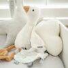 Baby Sense Taglet in soft pastel colors, featuring a plush design with tags for tactile exploration, placed in a crib
