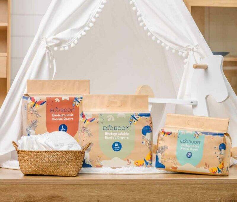 Eco Boom Joy Bamboo Baby Nappies in eco-friendly packaging displayed in a cozy nursery setting with a woven basket.
