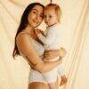 myboombra® bamboo nursing & maternity bra in black, worn by a mother holding her child against a soft, neutral backdrop.