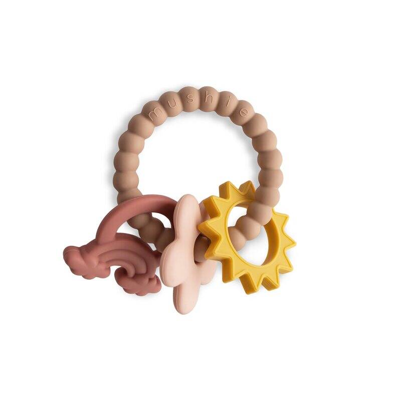 FRIGG + Mushie Nature Teething Ring in soft pink and yellow with textured silicone shapes for soothing infants.