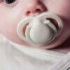 Tommee Tippee Trial Pack includes a 150ml bottle and a 0-2m soother, shown in use by a baby with a close-up view.