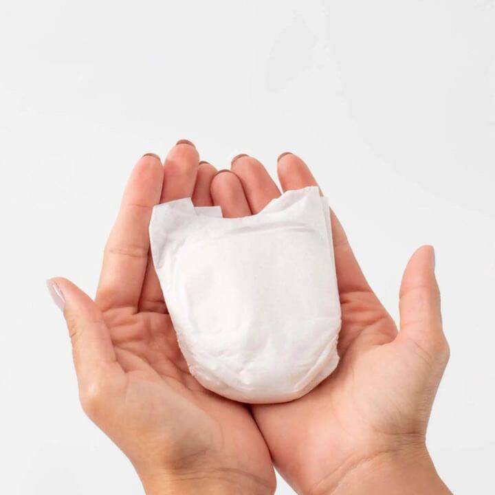My Little Prem Micro Preemie Nappies held in two hands, showcasing their small size and soft, white material.