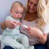 Tommee Tippee Baby & Toddler Nail Trimmer in use, with a mother gently trimming her child's nails in a cozy setting.