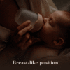 Difrax LOVI Mammafeel Bottle 150ml in a soft pink hue, held by a parent while a baby feeds in a cozy setting.