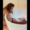 Little Bear Baby Bath Lilo in Duck Egg Blue, cradling a baby in a modern bathtub with a mother interacting lovingly.