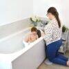Shnuggle Kneeler in use, providing comfort for a parent while bathing a child in a modern bathroom setting.