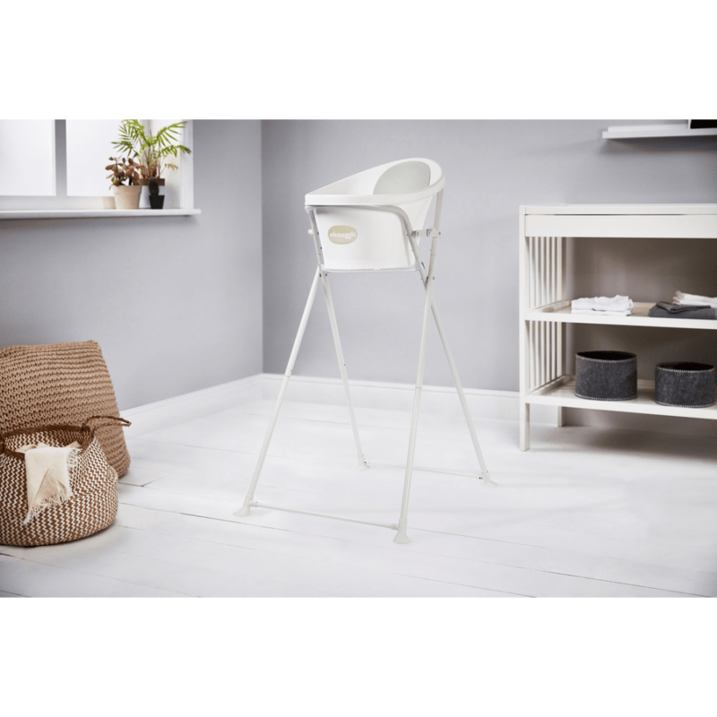 Shnuggle Folding Bath Stand in white, featuring a sturdy frame and a minimalist design, set in a modern bathroom.