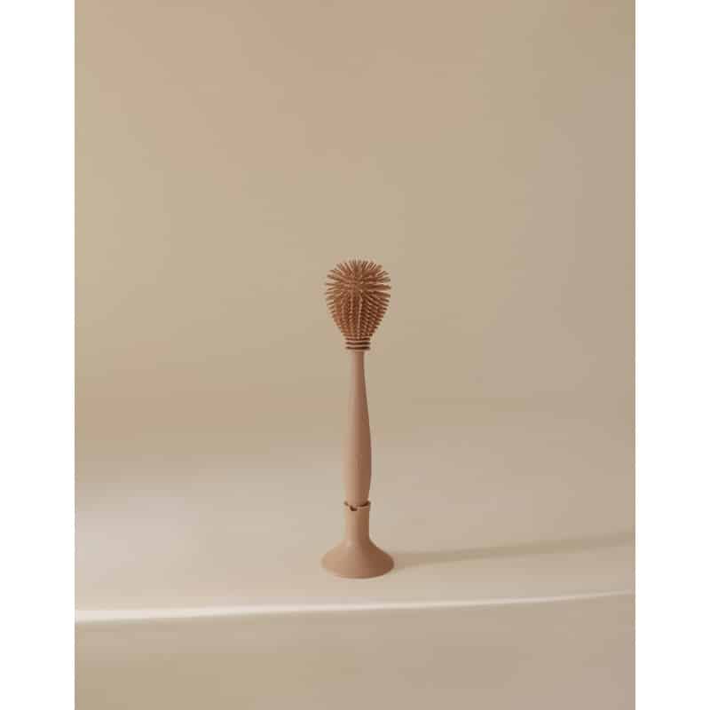 Mushie Silicone Baby Bottle Brush in Blush, featuring a textured head for effective cleaning, set against a neutral