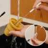 Haakaa Freeze-'n-Sip Ice Cream Mould Set in marigold, showing easy cleaning with a brush under running water.