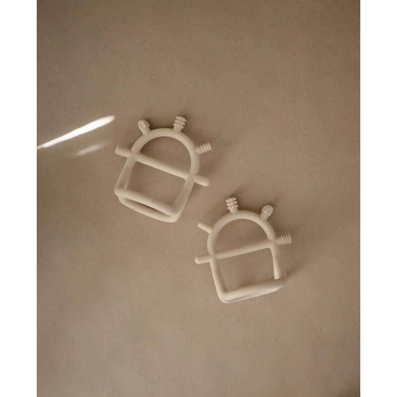 Mushie No-Drop Sensory Teether in blush and shifting sand, featuring a unique design with textured grips for easy handling.