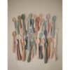 Mushie First Feeding Baby Spoons in various pastel colors, arranged artistically against a neutral background.
