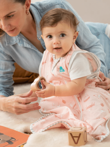 Love To Dream Swaddle Up Transition Bag in Daredevil Bunny Dusty Pink, featuring a playful design, shown on a baby during