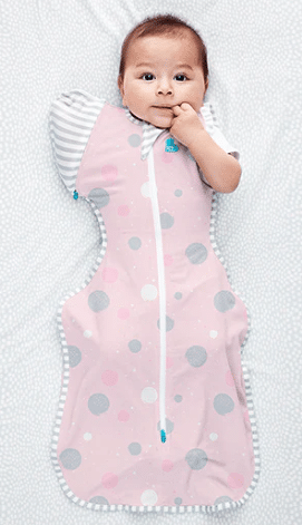Love To Dream Swaddle Up Transition Bag in Daredevil Bunny Dusty Pink with grey and pink circles, shown on a baby lying on a