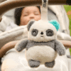 Tommee Tippee Mini Pip The Panda Travel Sleep Aid, soft plush panda with teal accent, hanging from stroller handle.