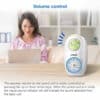 VTech DM1214 audio monitor with volume control displayed next to a woman using a laptop in a cozy home setting.