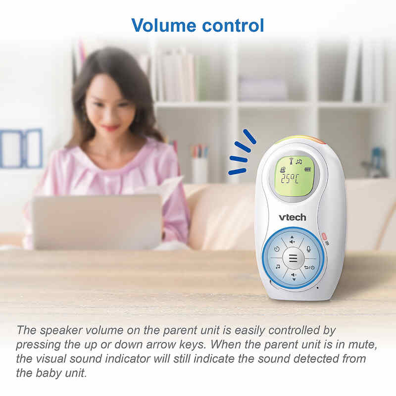 VTech DM1214 audio monitor with volume control displayed next to a woman using a laptop in a cozy home setting.