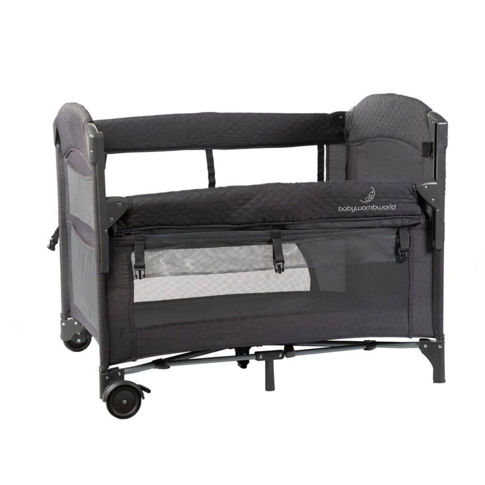 Baby Womb World Camping Cot and Co-Sleeper in dark grey with mesh sides and wheels for easy mobility.