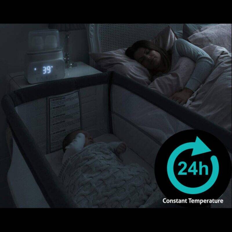 Baby Womb World Steam Sterilizer in a dimly lit nursery, showing a mother resting beside her baby in a bassinet.