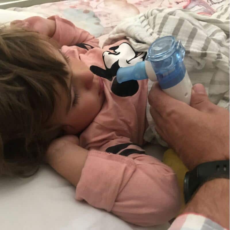 Baby Womb World Portable Nebuliser Machine in use, gently administering treatment to a resting child in a cozy bedroom