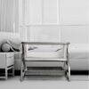 Baby Womb World Premium Bedside Crib Sleeper Cot with Mosquito Net in a modern bedroom setting next to a bed.