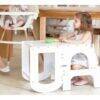 Baby Womb World 3-in-1 Convertible Stepstool, Desk Chair and Ladder in white, used as a desk by a child in a bright, modern