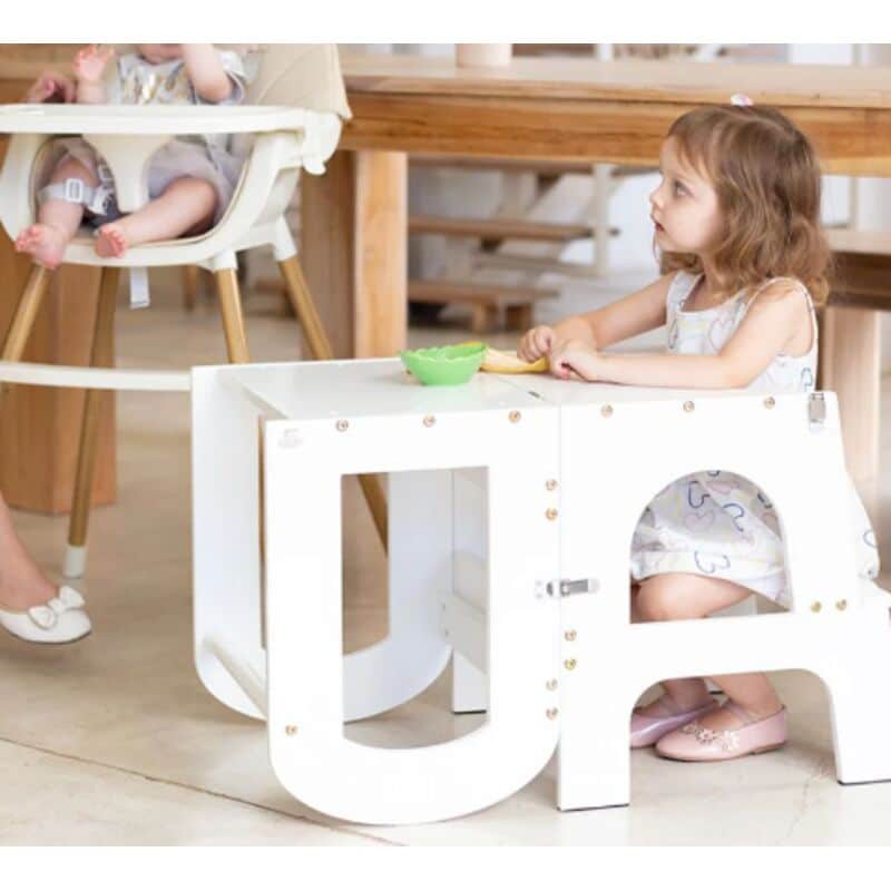 Baby Womb World 3-in-1 Convertible Stepstool, Desk Chair and Ladder in white, used as a desk by a child in a bright, modern