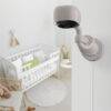 Hubble AI Vision security camera in soft beige, mounted on a wall near a nursery with a crib and soft decor.