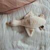 Flow Amsterdam Liva Heartbeat rechargeable comforter in beige and brown, shaped like a cozy duck, placed on a soft bed.