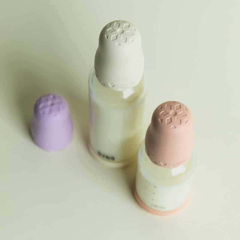 BIBS Glass Boheme Baby Bottle in Blush, Ivory, and Violet Sky with textured slow flow nipples on a light background.