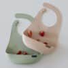Difrax LOVI Silicone Bibs in nude and pistachio, featuring a textured design and small strawberries inside.