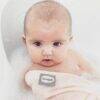 Shnuggle Bamboo Wash Cloth in soft pink, used during bath time with a baby in a bubble-filled tub.