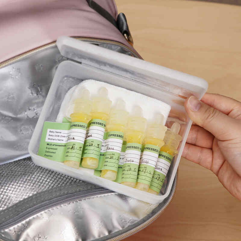 Haakaa Silicone Colostrum Collector Feeding Pack in a storage case, featuring pre-sterilised bottles labeled for easy