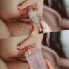 Haakaa Silicone Colostrum Collector Feeding Pack in use, showing a close-up of collection from the breast with a clear