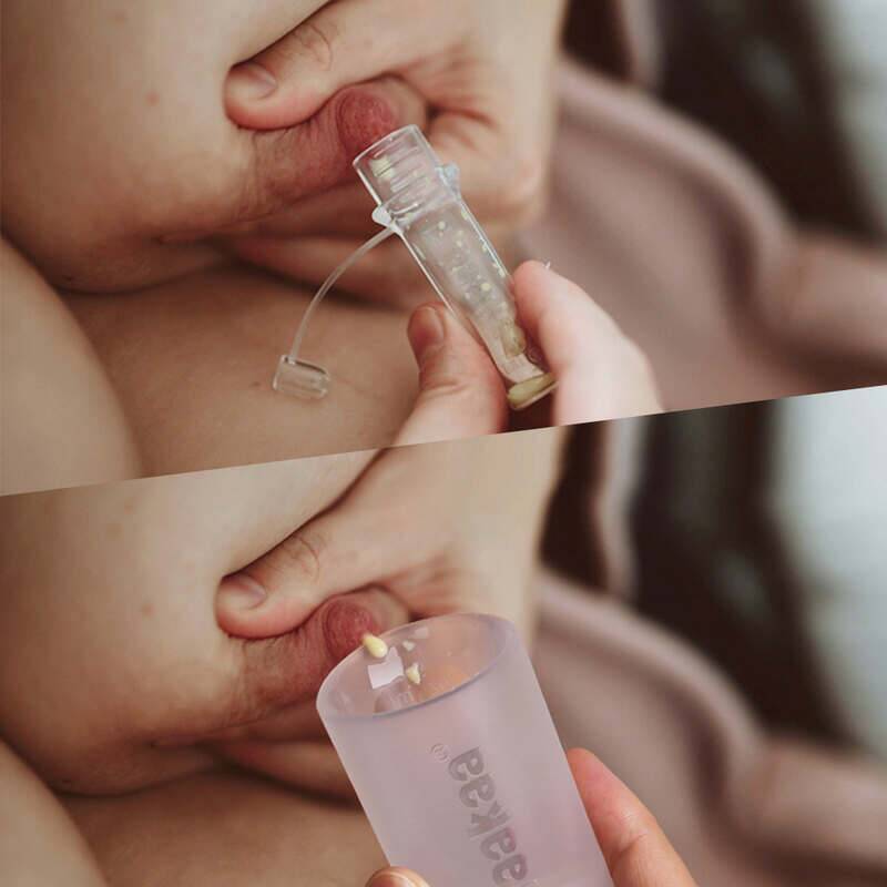 Haakaa Silicone Colostrum Collector Feeding Pack in use, showing a close-up of collection from the breast with a clear