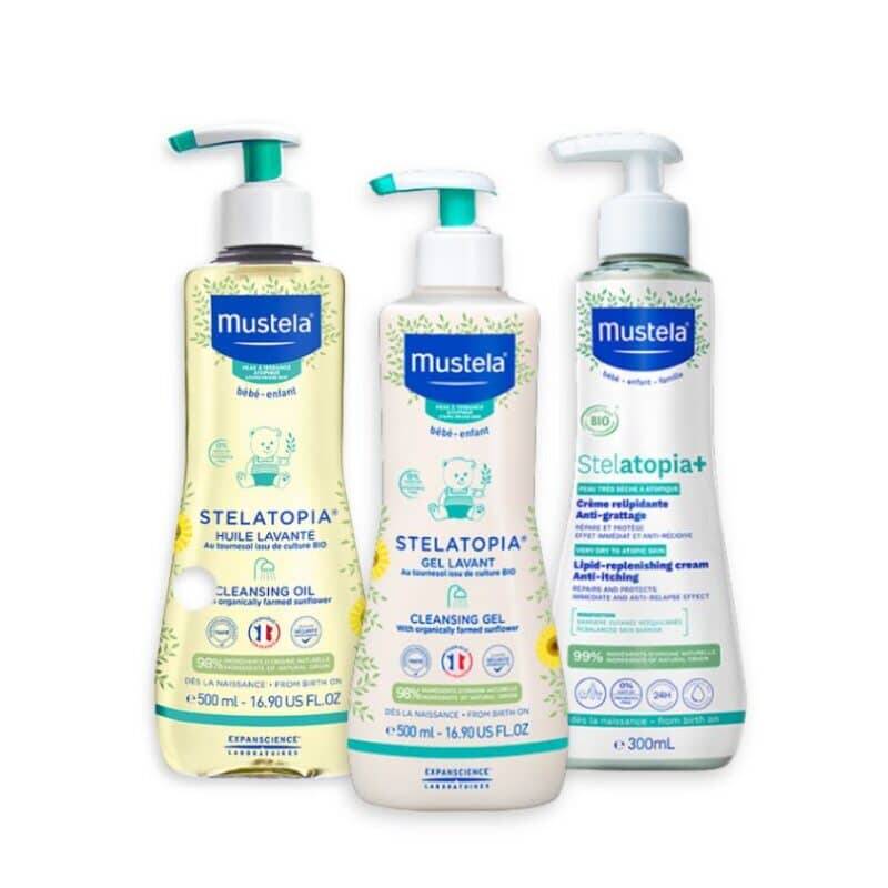 Mustela Stelatopia Bundle featuring cleansing oil, cleansing gel, and cream, all in pump bottles with colorful labels.